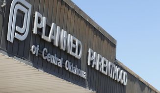 In this July 24, 2015, file photo, a sign at a Planned Parenthood Clinic is pictured in Oklahoma City. The furor on Capitol Hill over Planned Parenthood has stoked a debate about the use of tissue from aborted fetuses in medical research, but U.S. scientists have been using such cells for decades to develop vaccines and seek treatments for a host of ailments, from vision loss and neurological disorders to cancer and AIDS. (AP Photo/Sue Ogrocki/File)