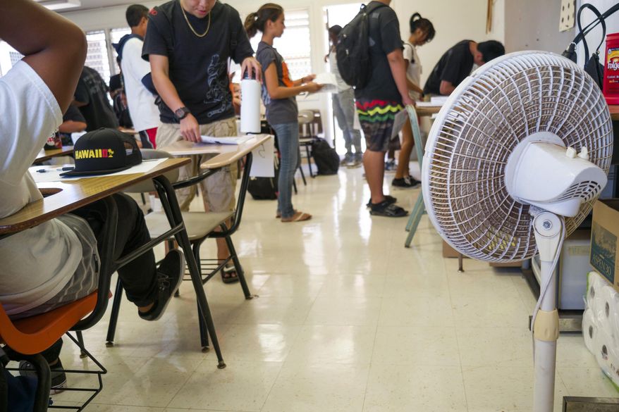 With only open windows and fans to cool the room down, students enter their non air conditioned classroom at Campbell High School, Monday, Aug. 3, 2015 in Ewa, Hawaii. Many public school classrooms across the Island are not equipped with AC, making it difficult for both teachers and students when the temperatures are high. In Hawaii, which has been experiencing record high temperatures, school officials are weighing whether it makes sense to have heat days, where they cancel school because it's simply too hot. (AP Photo/Marco Garcia)