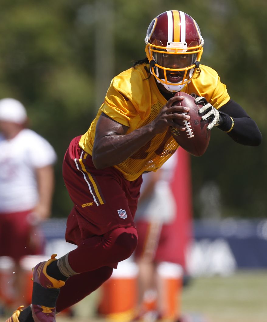 Washington Redskins quarterback Robert Griffin III rolls out during a drill at the NFL football team&#39;s training camp in Richmond, Va., on Tuesday, Aug. 11, 2015. (Dean Hoffmeyer/Richmond Times-Dispatch via AP)