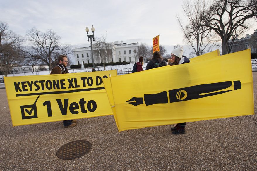 In this Feb. 24, 2015, file photo, Danny Ruthenberg-Marshall, left, with 350 DC, and Lindsey Halvorson, a student at American University, pick up their signs after attending gathering with other opponents of Keystone XL oil pipeline in support of a veto of the legislation outside the White House in Washington. (AP Photo/Jacquelyn Martin, File)