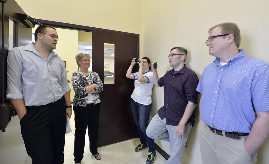 CORRECTS TO SAY THAT THE CLERK'S OFFICE WILL NOT BE ISSUING ANY MARRIAGE LICENSES, REGARDLESS OF WHETHER STRAIGHT OR SAME-SEX - Rowan County clerks Nathan Davis, left, and Roberta Earley, second left, inform David Ermold, right, and David Moore, second from right, that the county clerk's office will not be issuing marriage licenses to any couple, in defiance of an order from a federal judge, in Morehead, Ky., Thursday, Aug. 13, 2015. Rowan County Clerk Kim Davis has already filed a notice of appeal and plans to request a stay on the ruling. (AP Photo/Timothy D. Easley)