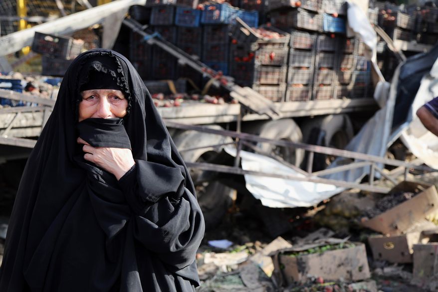 An Iraqi woman grieves at the scene of a bomb attack in Jameela market in the Iraqi capital's crowded Sadr City neighborhood Baghdad, Iraq, Thursday, Aug. 13, 2015. A massive truck bomb ripped through a popular Baghdad food market in a predominantly Shiite neighborhood in the early morning hours on Thursday, killing dozens of people, police officials said. (AP Photo/Karim Kadim)
