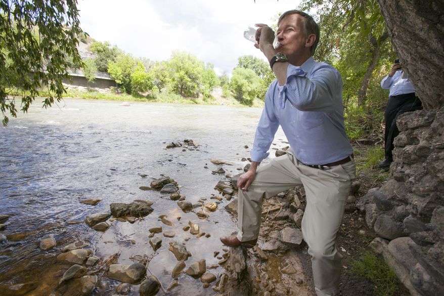 In this Tuesday, Aug. 11, 2015 photo, Colorado Gov. John Hickenlooper drinks water straight from the Animas River  in Durango, Colo., to get an update about the blowout from Gold King Mine. The water was treated with an iodine tablet before he drank it, to kill any giardia. (Shaun Stanley/The Durango Herald via AP) MANDATORY CREDIT