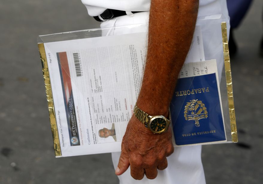 A man applying for a U.S. visa holds his U.S. Department of State forms and Cuban passport as he waits in line outside the U.S. Interests Section in Havana on July 1, 2015. (Associated Press) **FILE**