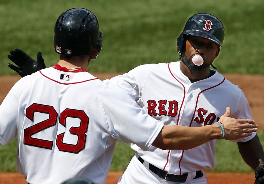 Boston Red Sox's Jackie Bradley Jr. blows a bubble as he is congratulated by Blake Swihart (23) after his two-run home run against the Seattle Mariners during the second inning of a baseball game at Fenway Park in Boston Saturday, Aug. 15, 2015. (AP Photo/Winslow Townson)