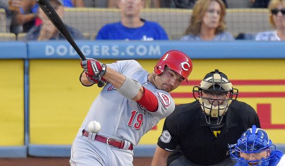 Cincinnati Reds&#39; Joey Votto hits an RBI double as Los Angeles Dodgers catcher Yasmani Grandal, right, watches along with home plate umpire Paul Nauert during the first inning of a baseball game, Friday, Aug. 14, 2015, in Los Angeles. (AP Photo/Mark J. Terrill)