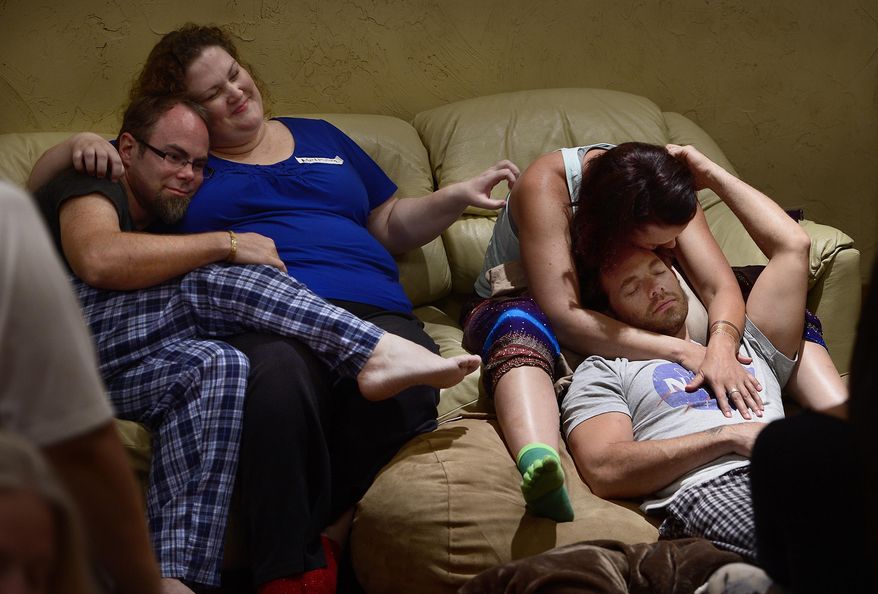 In this Friday, July 31, 2015 photo, In this Friday, July 31, 2015 photo, Joe Tuttle and Melissa Jones, left, and Hannah Laine and Jeff Cardon cuddle during a cuudle party, regular meet-up where strangers get together and cuddle in a nonsexual way, in Lindon, Utah. Three chapters of a national cuddle party organization meet regularly in Utah, where relative strangers, and a few old friends, meet up a four-hour cuddle party. They say holding hands, getting foot massages or running fingers through someone’s hair helps spread good vibes and give people nonsexual human connections. (Scott Sommerdorf /The Salt Lake Tribune via AP) DESERET NEWS OUT; LOCAL TELEVISION OUT; MAGS OUT; MANDATORY CREDIT