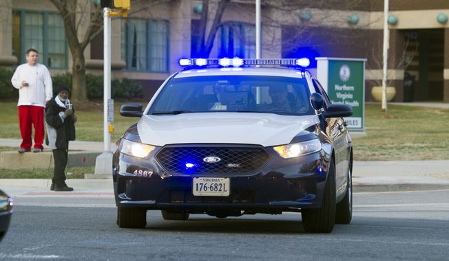 In this March 31, 2015, file photo, a Fairfax County, Va., police cruiser is shown with its emergency lights on. (Associated Press) ** FILE **