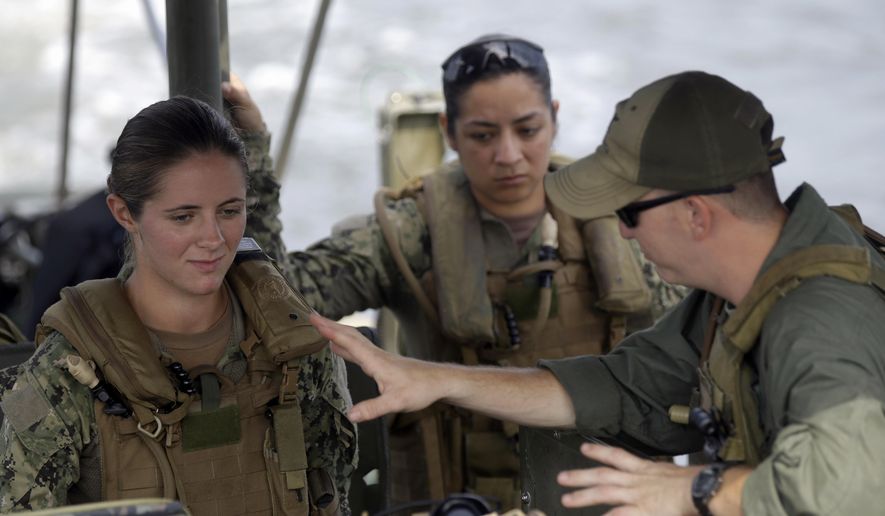 U.S. Navy Master-at-Arms Third Class Danielle Hinchliff, left, and Master-at-Arms Third Class Anna Schnatzmeyer, center, participate in a U.S. Navy Riverine Crewman Course under instructor Boatswain&#39;s Mate Second Class Christopher Johnson, right, on a Riverine Assault Boat at Camp Lejeune, N.C.  (AP Photo/Gerry Broome, File)
