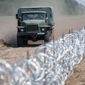 Razor wire marks the border between Hungary and Serbia, but officials are planning to erect a 109-mile-long, 13-foot-tall fence. (Associated Press)