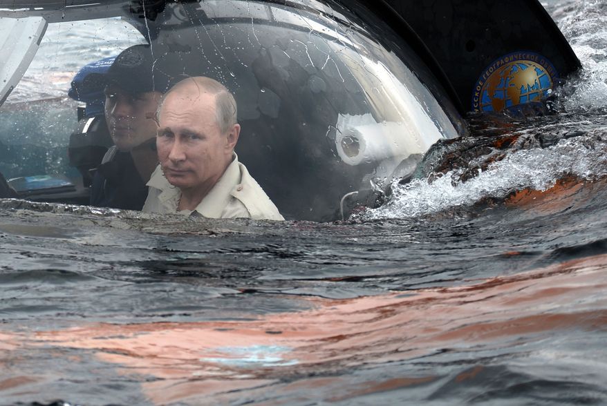 Russian President Vladimir Putin, centre, sits on board a bathyscaphe as it plunges into the Black sea along the coast of Sevastopol, Crimea, Tuesday, Aug. 18, 2015. President Vladimir Putin plunged into the Black Sea to see the wreckage of a sunk ancient merchant ship which was found in the end of May. (Alexei Nikolsky/RIA-Novosti, Kremlin Pool Photo via AP)