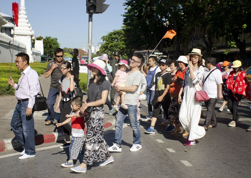 Chinese tourists cross the street in front of the Grand Palace in Bangkok, Thailand, Wednesday, Aug. 19, 2015. The bomb blast that ripped through a Bangkok shrine, leaving scores of casualties, may take a toll on  the country&#39;s tourism industry, the one bright spot in Thailand’s blighted economy. (AP Photo/Penny Yi Wang)