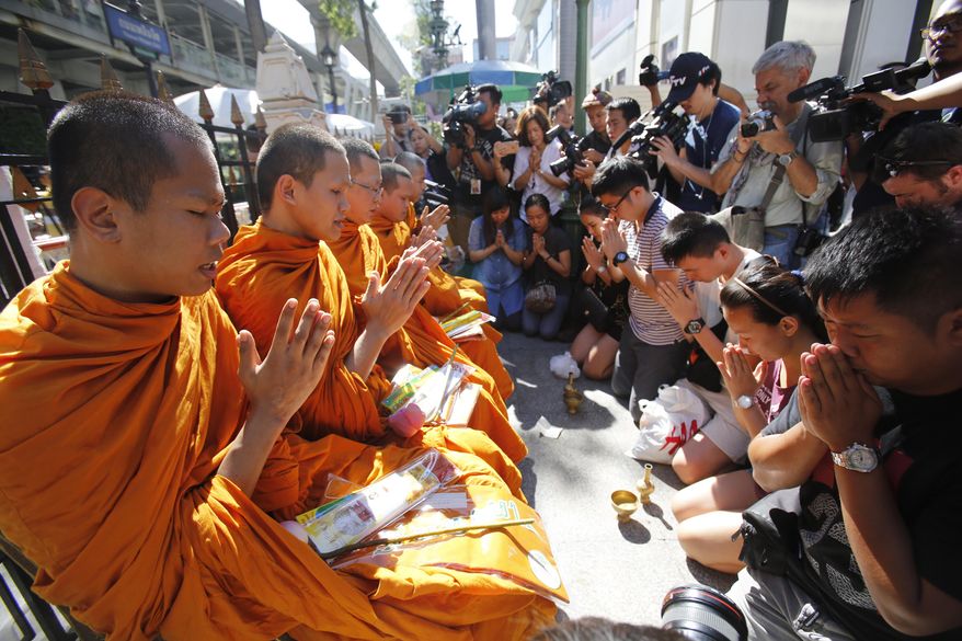 Buddhist monks hold a prayer at the Erawan Shrine at Rajprasong intersection in Bangkok, Thailand, Wednesday, Aug. 19, 2015. The central Bangkok shrine reopened Wednesday to the public after Monday&#39;s bomb blast as authorities searched for a man seen in a grainy security video who they say was the prime suspect in an attack authorities called the worst in the country&#39;s history. (AP Photo/Sakchai Lalit)