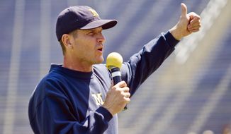 FILE - In this Aug. 6, 2015, file photo, Michigan head coach Jim Harbaugh greets fans in Michigan Stadium during the NCAA college football team&#39;s annual media day in Ann Arbor, Mich. It felt at times like Jim Harbaugh&#39;s every move was being monitored this offseason, such is the level of excitement and anticipation surrounding his arrival at Michigan. (AP Photo/Tony Ding, File)