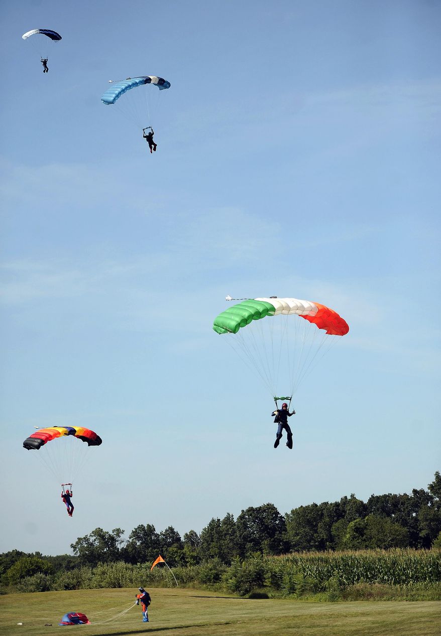 In this Friday, Aug. 7, 2015 photo, parachuters land at Ellington Airport in Ellington, Conn. Alex Kelly, man who gained international infamy as the “preppy rapist” has found a career since his release from prison as a Connecticut-based skydiving instructor. Kelly spent six years with Connecticut Parachutists Inc., in Ellington before the company asked him to resign last year over what company officials describe as erratic behavior. He recently bought a plane and is preparing to open his own Connecticut-based parachuting business. (AP Photo/Jessica Hill)