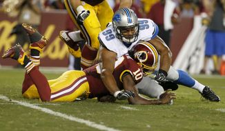 Washington Redskins quarterback Robert Griffin III (10) is hit by Detroit Lions defensive end Corey Wootton (99) while trying to recover a fumble during the first half of an NFL preseason football game, Thursday, Aug. 20, 2015, in Landover, Md. Griffin was injured during the play and left the game. (AP Photo/Alex Brandon)