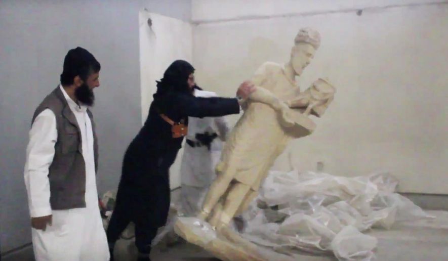 In this image made from video posted on a social media account affiliated with the Islamic State group on Thursday, Feb. 26, 2015, which has been verified and is consistent with other AP reporting, a militant topples an ancient artifact in the Ninevah Museum in Mosul, Iraq. (AP Photo via militant social media account) ** FILE **