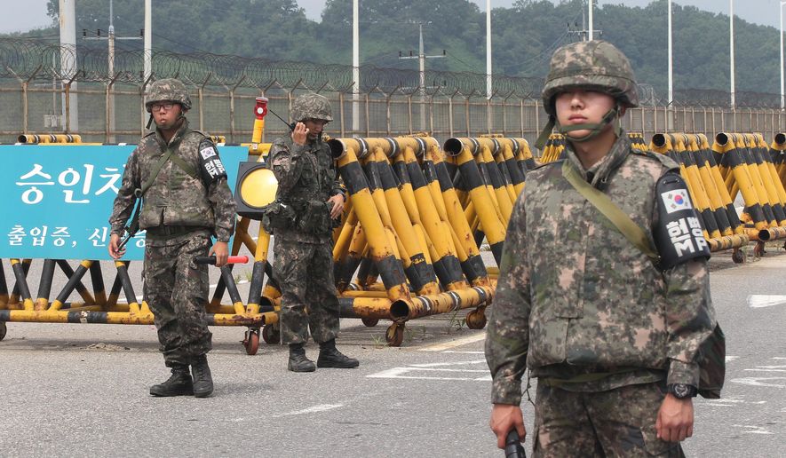 South Korean army soldiers stand guard at Unification Bridge near the border village of Panmunom in Paju, South Korea, Friday, Aug. 21, 2015. South Korea fired dozens of shells Thursday at rival North Korea after the North lobbed several rounds across the world's most heavily armed border and threatened to take further action unless Seoul ends its loudspeaker broadcasts. The North denied it fired any shots and warned of retaliation for what it called a serious provocation. (AP Photo/Ahn Young-joon)