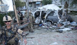 Afghan security forces and British soldiers inspect the site of a suicide attack in the heart of Kabul, Afghanistan, Saturday, Aug. 22, 2015. The suicide car bomber attacked a NATO convoy traveling through a crowded neighborhood in Afghanistan&#39;s capital Saturday, killing at least 10 people, including three foreign contractors, authorities said. (AP Photo/Massoud Hossaini
