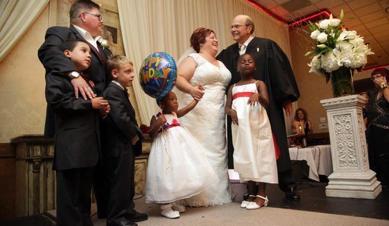 Jayne Rowse, left, and April DeBoer, right, legally marry with their children on stage at the banquet hall in Southfield, Mich. on Saturday, Aug. 22, 2015. The US Supreme Court struck down bans on same-sex marriage nation wide on Friday, June 26, 2015. Judge Bernard Friedman, of U.S. District Court of Eastern Michigan, who overturned Michigan&#39;s ban on gay marriage officiated the marriage of the two Hazel Park nurses at the center of the groundbreaking case.  (Kimberly P. Mitchell/Detroit Free Press via AP)