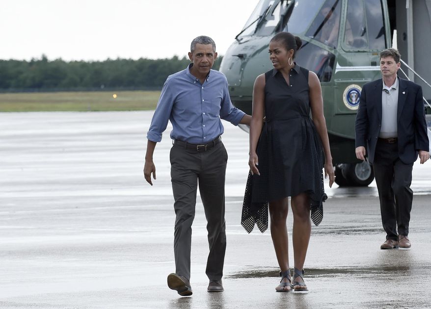 President Barack Obama and first lady Michelle Obama walk over to greet people before boarding Air Force One at Air Station Cape Cod, in Mass., Sunday, Aug. 23, 2015. The president is returning to Washington after he and his family spent more than two weeks vacationing on the Massachusetts island of Martha's Vineyard. (AP Photo/Susan Walsh)