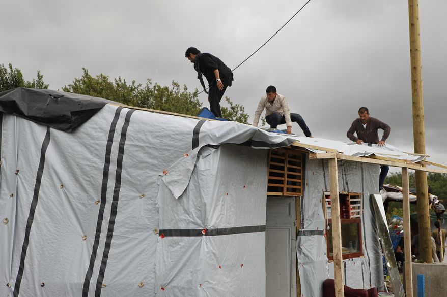Migrants build a temporary shelter at the migrant camp known as the New Jungle in Calais, northern France, on Aug. 20. Britain and France are fortifying control of the Channel Tunnel and boosting intelligence efforts against traffickers as they try to dissuade thousands of migrants trying to make the illegal and sometimes deadly undersea journey to British shores. (Associated Press)