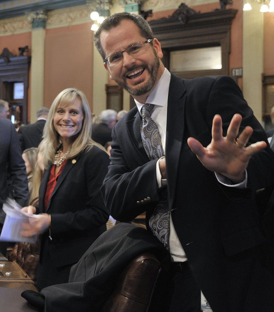 FILE- In this Jan. 14, 2015 file photo, Rep. Cindy Gamrat, R-Plainwell, and Rep Todd Courser, R-Lapeer wave to reporters in the House of Representatives in Lansing, Mich. A preliminary investigation into the two lawmakers who had an affair found misconduct and misuse of taxpayer resources — a finding that could lead to their expulsion from the Legislature. A draft report on the findings involving the lawmakers was submitted to an outside counsel for review, House Business Office Director Tim Bowlin said Monday, Aug. 24, 2015 in a news release. (Dale G. Young /Detroit News via AP) DETROIT FREE PRESS OUT; HUFFINGTON POST OUT; MANDATORY CREDIT