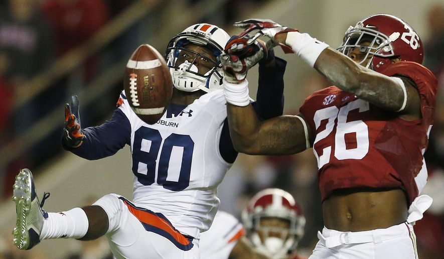 In this Nov. 29, 2014, file photo, Alabama defensive back Landon Collins (26) breaks up a pass meant for Auburn wide receiver Marcus Davis (80) during the first half of the Iron Bowl NCAA college football game in Tuscaloosa, Ala. Go into the bowl season with a chance to win the national championship. That's mostly been the case in recent years and no reason to think it won't happen again for these two teams. College football's most intense in-state rivalry has been wild the past two seasons with the Kick-6 going Auburn's way in 2013 and then a record-setting shootout being won by Alabama in 2015. The teams will meet Nov. 28, 2015 at Auburn. (AP Photo/Butch Dill, File)