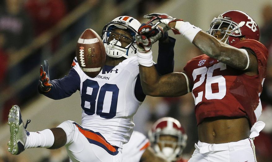 In this Nov. 29, 2014, file photo, Alabama defensive back Landon Collins (26) breaks up a pass meant for Auburn wide receiver Marcus Davis (80) during the first half of the Iron Bowl NCAA college football game in Tuscaloosa, Ala. Go into the bowl season with a chance to win the national championship. That's mostly been the case in recent years and no reason to think it won't happen again for these two teams. College football's most intense in-state rivalry has been wild the past two seasons with the Kick-6 going Auburn's way in 2013 and then a record-setting shootout being won by Alabama in 2015. The teams will meet Nov. 28, 2015 at Auburn. (AP Photo/Butch Dill, File)