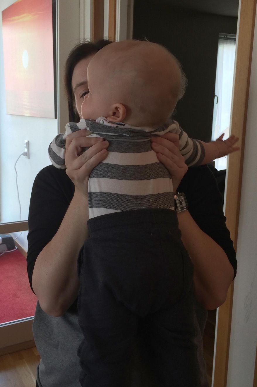 A young Swedish mother holds her child in an apartment in Gothenburg Sweden Sunday Aug. 16, 2015. For this family in Sweden, a pioneering procedure has led to a baby being born from the same womb that nurtured his mother, uniting three generations. The new mother, who lost her own uterus to cancer in her 20s, said it was “unimaginable” that she now had her own child, thanks to her mother’s donated womb. (AP Photo/Maria Cheng)