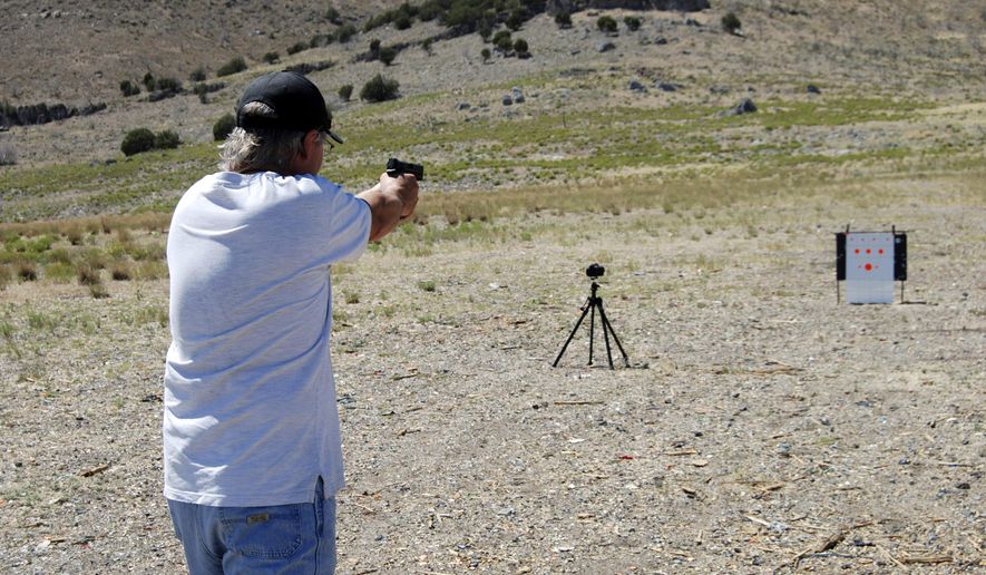 In this Aug. 4, 2015, photo, a man takes aim at paper targets with a 9mm handgun on public lands west of Utah Lake. The Bureau of Land Management is working on a plan to reign in target shooting on 9,000 acres of public land near Utah Lake in exchange for giving 160 acres to Utah County for a shooting range. (Brian Maffly/The Salt Lake Tribune via AP) DESERET NEWS OUT; LOCAL TELEVISION OUT; MAGS OUT; MANDATORY CREDIT