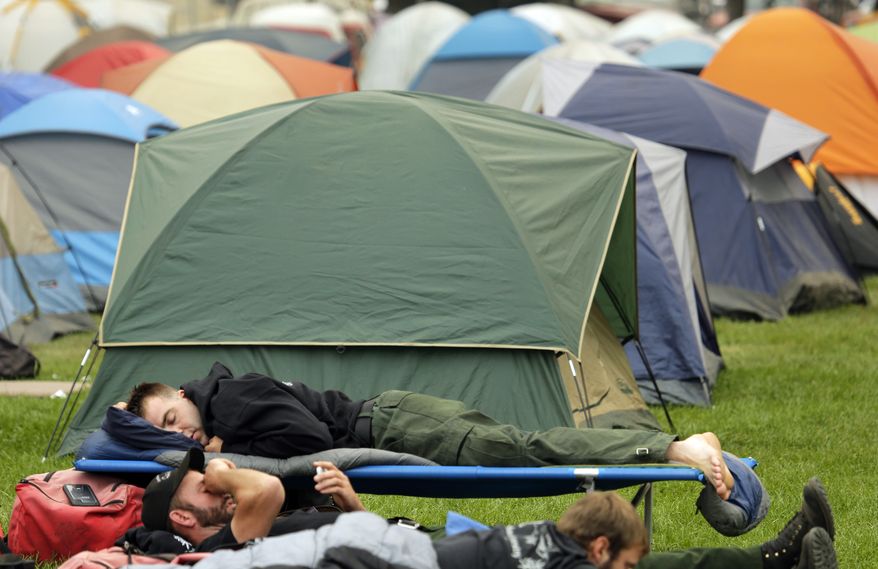 Mike Hansen, top, and Scott Nelson, bottom, both firefighters with Oregon-based Grayback Forestery rest at a camp for firefighters battling the Okanogan Complex Fire in Okanogan, Wash., Tuesday, Aug. 25, 2015. The firefighters were resting before their first day fighting fires in Washington state after battling blazes in California for the past three weeks and they were sleeping in the open because they were expecting to move to a different camp on Wednesday. (AP Photo/Ted S. Warren)