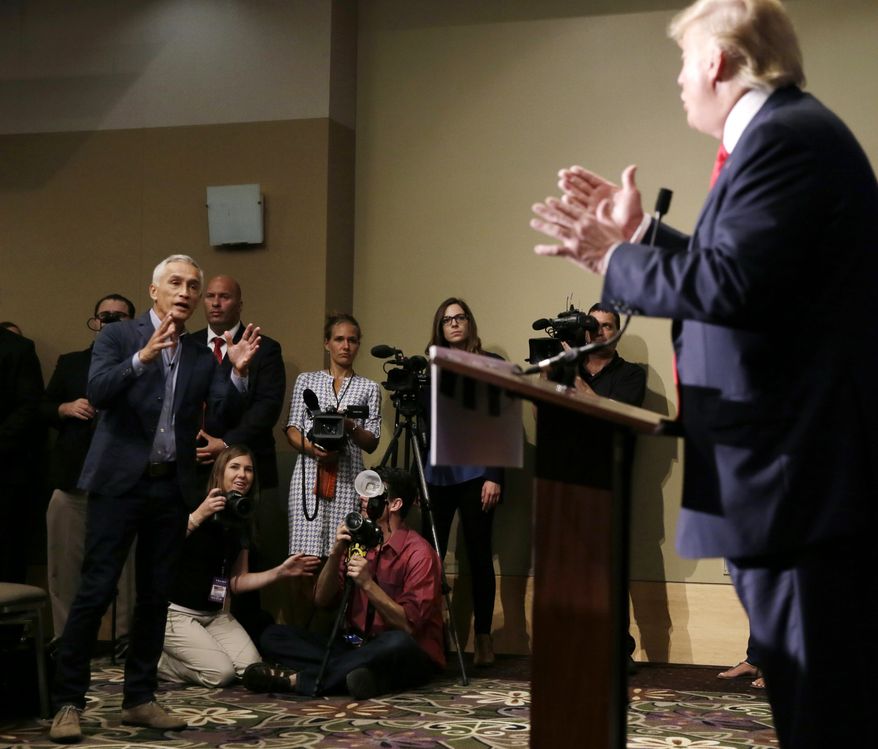 Miami-based Univision anchor Jorge Ramos, left, asks Republican presidential candidate Donald Trump a question about his immigration proposal during a news conference, Tuesday, Aug. 25, 2015, in Dubuque, Iowa. Ramos was later removed from the room. (AP Photo/Charlie Neibergall)