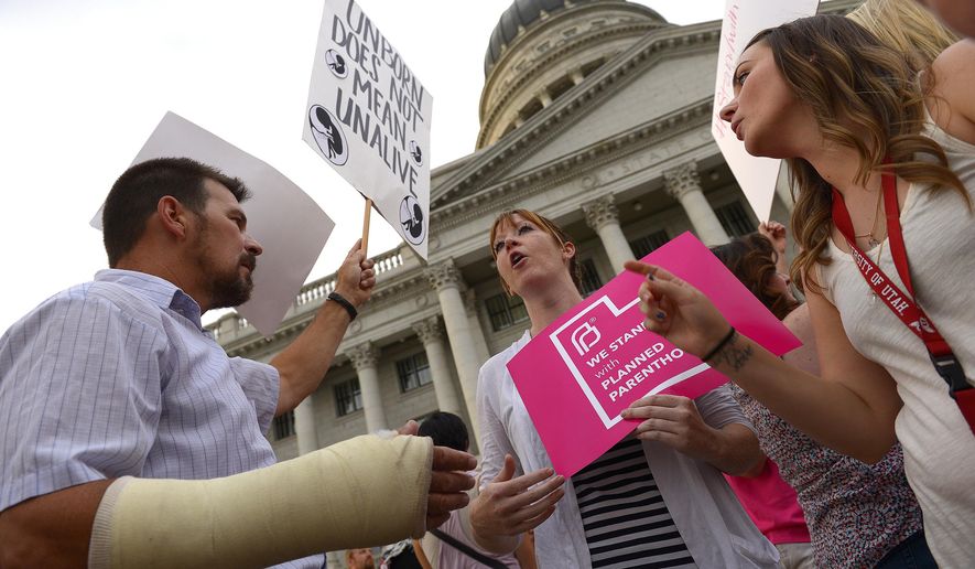 Brandi Jensen, center, shares her opinions with an anti-Planned Parenthood protester as Planned Parenthood Action Council holds a community rally at the state Capitol in Salt Lake City on Aug. 25, 2015. Planned Parenthood Association of Utah CEO Karrie Galloway says the demonstration is a protest against Gov. Gary Herbert&#39;s decision to stop disbursing federal money to Planned Parenthood. (Leah Hogsten/The Salt Lake Tribune via AP) **FILE**