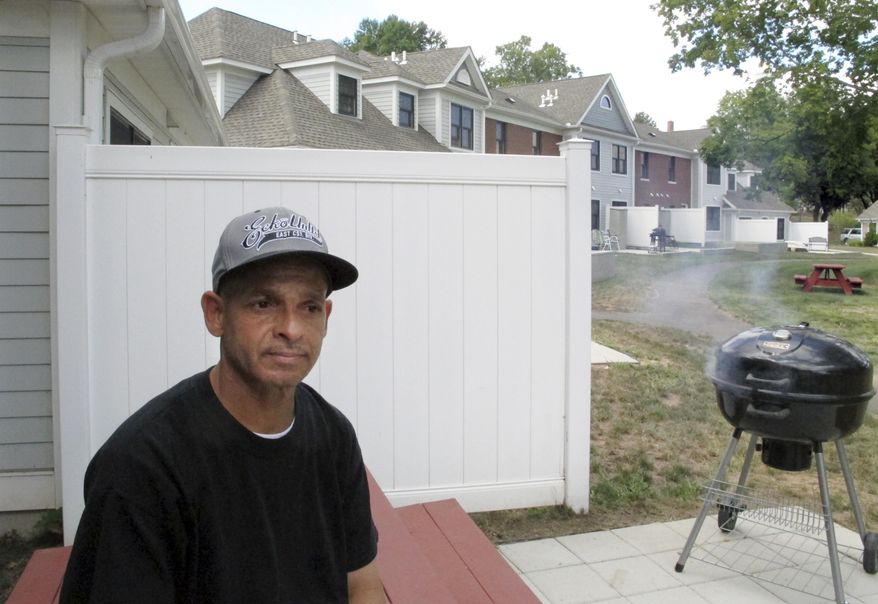 Luis Vazquez, a 49-year-old Navy veteran who was homeless off and on for 10 years, sits outside his home in a veterans' housing complex Thursday, Aug. 27, 2015, in Newington, Conn. U.S. Veterans Affairs Secretary Robert McDonald and Connecticut officials were at the housing complex Thursday to announce that the state is the first in the country to end chronic homelessness among veterans. (AP Photo/Dave Collins)