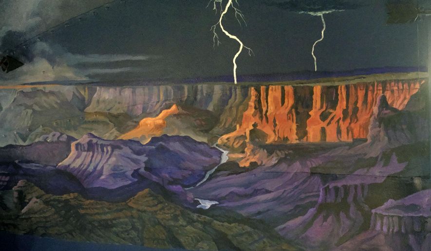 In this Aug. 11, 2015 photo, artist Janet Bedford of Powell, Wyo., painted the bedroom walls of an Airstream trailer into a night scene with stormy skies, cowboy campfires, the Grand Canyon and Old Faithful in the moonlight, in Powell, Wyo. Camping is an art, they say, and Powell artist Janet Bedford is transforming a camper trailer into a literal work of art. Bedford is painting the concave interior walls of a vintage 1948 Airstream trailer into a colorful canvas depicting scenes from national parks across the country. (Matt Naber/The Powell Tribune via AP) MANDATORY CREDIT
