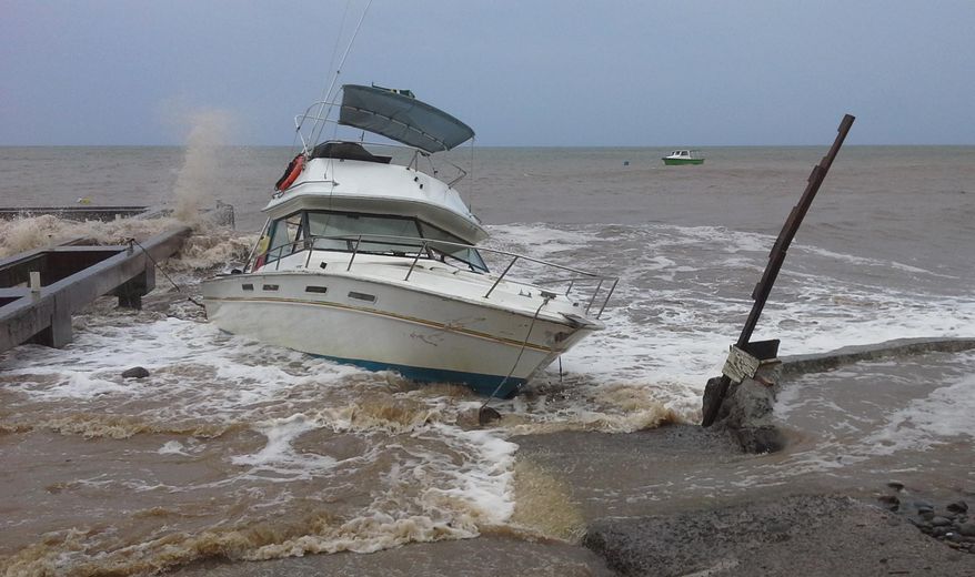 A boat sits in shallow water as Tropical Storm Erika passes through New Town, Dominica, Thursday, Aug. 27, 2015. (AP Photo/Carlisle Jno Baptiste) ** FILE **