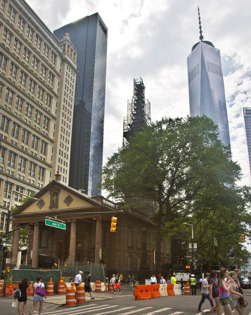 In this June 25, 2015, file photo, the World Trade Center, right, looms behind St. Paul's Chapel with its steeple wrapped in scaffolding for repairs, in New York. The winner of a new competition open to people of all faiths, called "The Reconciliation Preaching Prize," has been won by an Army chaplain from Austin, Texas. The Rev. David Peters will have the privilege of delivering an original sermon on Sept. 11, at the chapel near ground zero that was turned into a makeshift memorial shrine and became a place of rest and renewal for volunteers and responders, following the terrorist attacks that brought down the twin towers. (AP Photo/Bebeto Matthews, File)