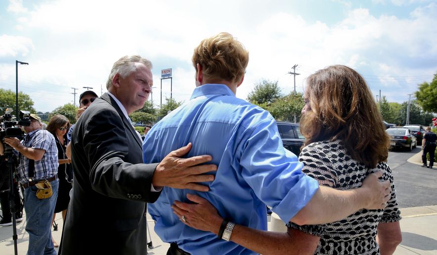 Virginia Gov. Terry McAuliffe, left, and his wife, Dorothy, right, visit with Chris Hurst, boyfriend of slain WDBJ-TV journalist Alison Parker, Friday, Aug. 28, 2015, in Roanoke, Va. Parker and fellow WDBJ-TV journalist Adam Ward were killed Wednesday by former colleague Vester Flanagan during a live broadcast. (Stephanie Klein-Davis/The Roanoke Times via AP)