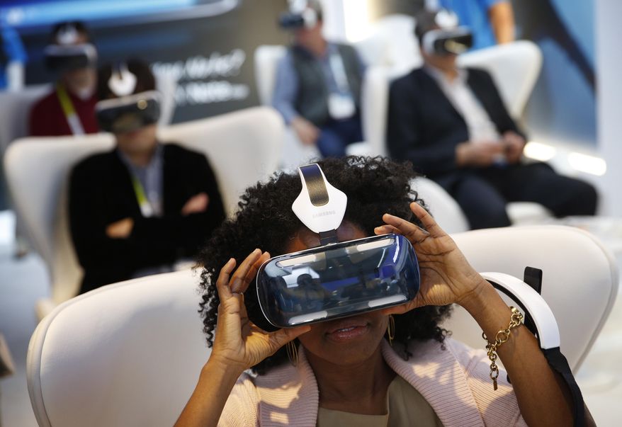 In this Jan. 6, 2015 file photo, Yasmin Moorman looks into the Galaxy Gear VR headset at the Samsung booth during the International CES, in Las Vegas. (AP Photo/John Locher, File)