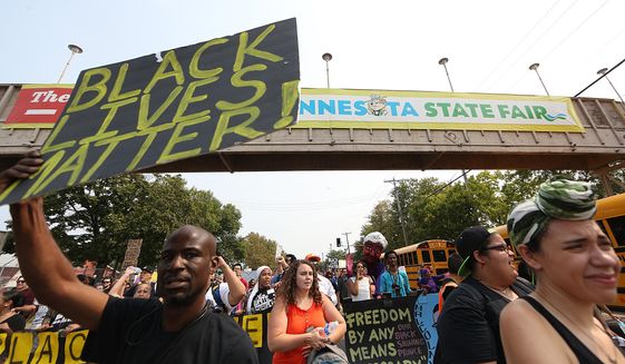 People march during a Black Lives Matter protest near the front gate of the Minnesota State Fair in Falcon Heights on Aug. 29, 2015. (Jim Gehrz/Star Tribune via Associated Press)
