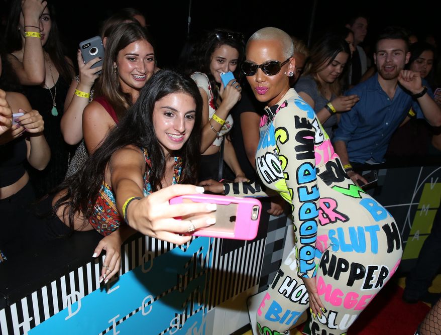 Amber Rose, right, takes a photo with a fan as she arrives at the MTV Video Music Awards at the Microsoft Theater on Sunday, Aug. 30, 2015, in Los Angeles. (Photo by Matt Sayles/Invision/AP)