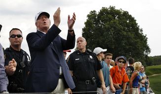 Republican presidential candidate Donald Trump, second left, applauds play as he walks with a crowd during the final round of play at The Barclays golf tournament Sunday, Aug. 30, 2015, in Edison, N.J. (AP Photo/Mel Evans)