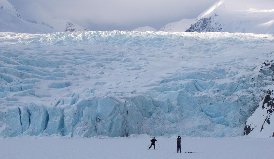 In this March 29, 2006 photo, a skier poses for a photograph on Portage Lake in front of Portage Glacier, about 50 miles south of Anchorage, Alaska. The Portage Glacier, which is a major Alaska tourist destination near Anchorage has retreated so far it no longer can be seen from a multimillion-dollar visitors center built in 1986. President Obama leaves Monday, Aug. 31, 2015 for a three-day visit to the 49th state in which he will speak at a State Department climate change conference and become the first president to visit the Alaska Arctic. There and even in the sub-Arctic part of the state, he will see the damage caused by warming, damage that has been evident to scientists for years. (Evan R. Steinhauser/Anchorage Dispatch News via AP, File)