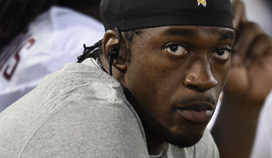 Washington Redskins quarterback Robert Griffin III sits on the sideline in the second half of a preseason NFL football game against the Baltimore Ravens, Saturday, Aug. 29, 2015, in Baltimore. (AP Photo/Gail Burton)
