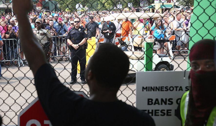Black Lives Matter protesters agitate at the front gate of the Minnesota State Fair during a protest Saturday. Some fear the protest movement may be promoting violence against police that contributed to a Houston deputy&#39;s slaying by a black man Friday. (Star Tribune via Associated Press)