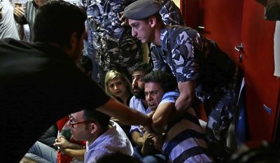 A Lebanese policeman, right, tries to drags away an anti-government activist during a sit-in protest against Environment Minister Mohammed Machnouk, inside the Environment Ministry, in downtown Beirut, Lebanon, Tuesday, Sept.1, 2015. Lebanese protesters broke into the Environment Ministry in downtown Beirut Tuesday, demanding the resignation of the minister over the country’s snowballing trash crisis. (AP Photo/Hassan Ammar)