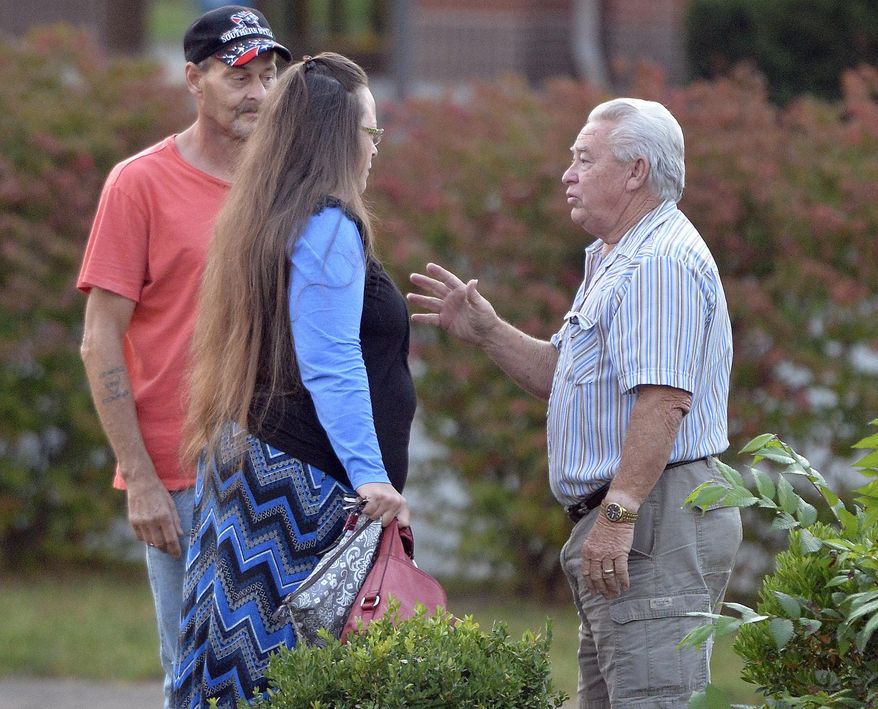 Rowan County Clerk Kim Davis, foreground left, is greeted as she arrives for work at the Rowan County Courthouse in Morehead, Ky., Tuesday, Sept. 1, 2015. Davis' appeal to the U.S. Supreme Court was turned down on Monday, and now she is under federal orders to begin issuing marriage licenses. (AP Photo/Timothy D. Easley)