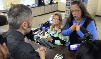 Rowan County Clerk Kim Davis, right, talks with David Moore following her office&#39;s refusal to issue marriage licenses at the Rowan County Courthouse in Morehead, Ky., Tuesday, Sept. 1, 2015. (AP Photo/Timothy D. Easley)