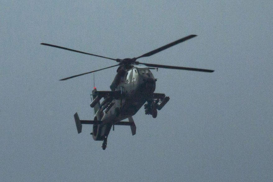 FILE - In this Aug. 23, 2015 file photo, a Chinese Z-19 military attack helicopter flies over central Beijing during a rehearsal for a large military parade. When China rolls out its latest armaments Thursday, Sept. 3, for a lavish parade commemorating the defeat of Japan in World War II, defense experts and foreign armies will be watching closely for any revelations about new military capabilities. (AP Photo/Ng Han Guan, File)